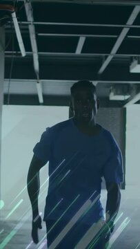 Vertical video: Runner racing from exit to cam in garage light streaks tracking watch for training
