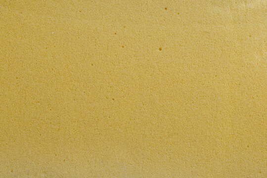 Macro texture of old yellow foam with aged porous surface