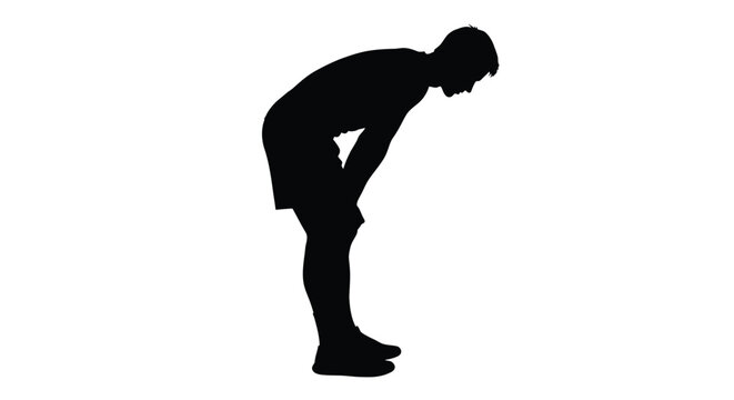 A man bending over hands on knees in a dark silhouette