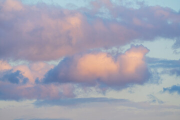 Fototapeta premium Close-up of soft pink and blue clouds at sunset. Dreamy sky texture.