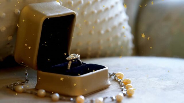 Camera shifting left, revealing ring box and pearl, golden stars drifting, showcasing jewelry