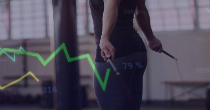 Reacting to data readouts, female wearing fitted tank top and leggings performing jump rope at gym