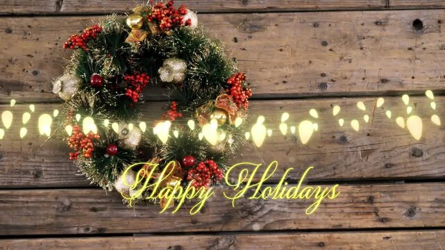 Animation of happy holidays text over wreath on wooden background