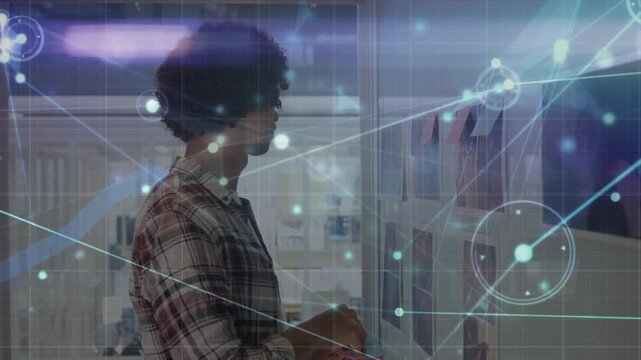 African american businessman using sticky notes on photographs and dots connecting with lines