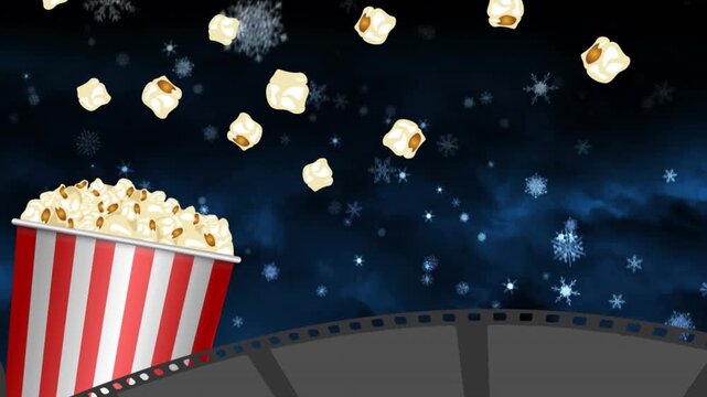 Film reel and popcorn tub icon over snowflakes falling against blue background