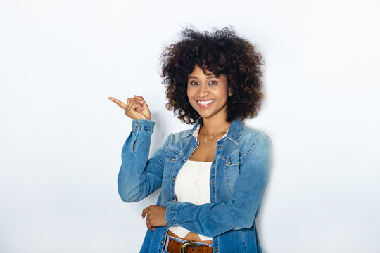 young woman with afro hair isolated on background pointing