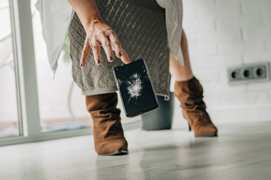 woman and falling broken mobile phone