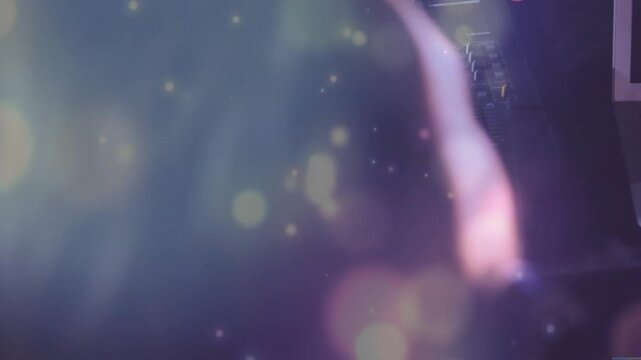 Right hand pressing key and making tech user leaning, adjusting screen, purple bokeh hiding headset