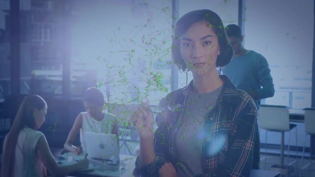 Woman adjusting glasses stepping forward and pointing at network overlay in tech office, presenting