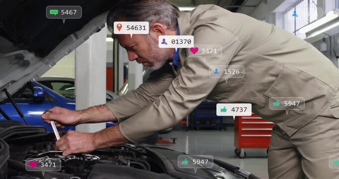 Male auto mechanic grabbing tool, fixing engine under hood, notifications multiplying around arms