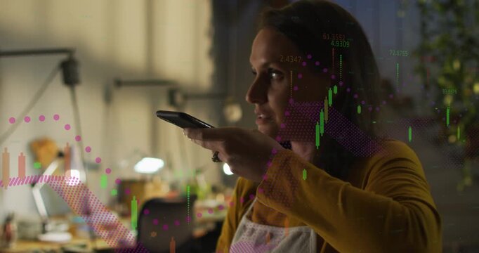 Woman raising phone speaking at desk finance charts evolving projecting over face analyzing sales