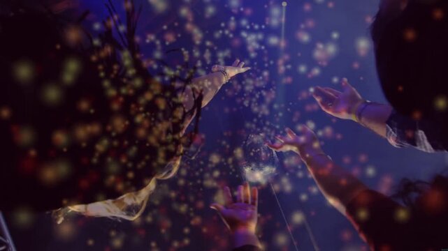Vertical video: Event crowd reaching toward disco ball as gold particles scattering, hands catching