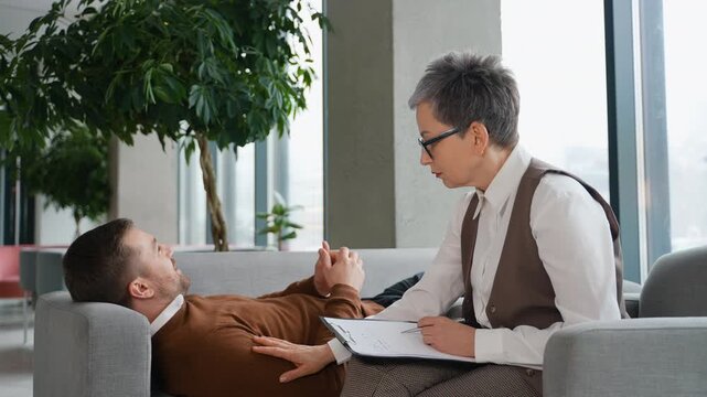 Male patient talking to a female psychologist during a therapy session