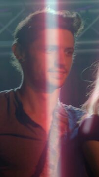 Vertical video: Woman smiling as guitarist entering stage, reframing for show with strap and lights