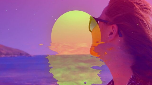 Animated sun graphic fading in causing woman at shoreline smiling, raising bottle for marketing