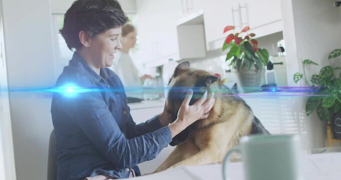 Woman smiling and leaning cupping dog head checking ears for pet care blue streak crossing hands