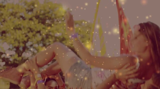 Vertical video: Crowd lifting and passing woman across park to move her ahead, showing denim shorts