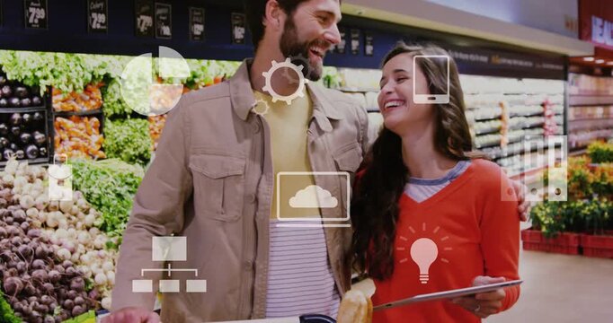 Couple consulting tablet while choosing produce in aisle, overlay icons hovering, touching, leaning