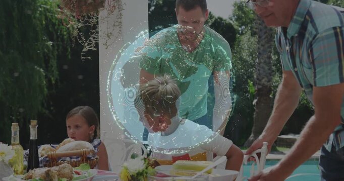 Adults arranging table setup, boy reaching food then settling while globe pulsing over scene