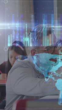 Vertical video: Man leaning, taking notes in class while hologram bars, world map pulsing over desk
