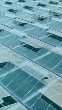 Vertical video: Camera panning along glass roof panels and vents, overlaying bar chart for farming