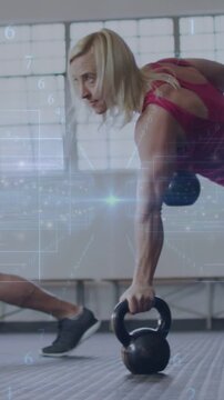 Vertical video: Woman gripping KBs in plank, alternating rows for fitness with HUD overlay drifting