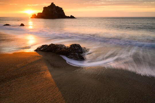 Sunset light waves and sea stack at the beach, Aichi, Japan