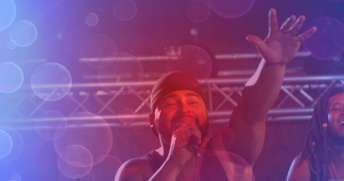 Lens flare clearing revealing lead singer drawing hand mic closer and singing music engaging crowd