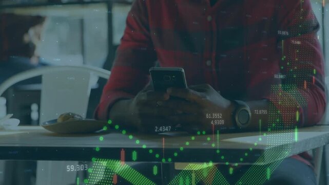 Seated man tapping phone in cafe, causing finance charts rising on table near hands tracking stocks