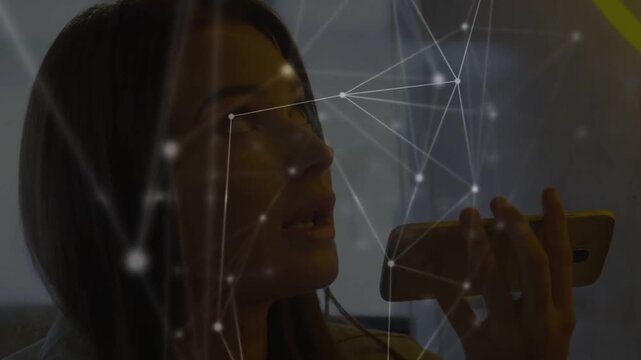 Woman starting with smartphone near mouth, dictating notes while node network overlay drifting