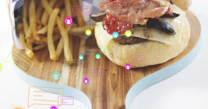 Vertical video: Camera panning down showing burger and fries on board icons clustering for food ads