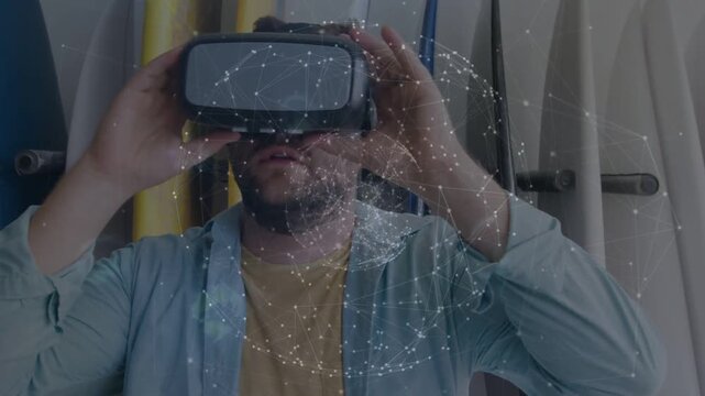 Mid-adult man bringing VR headset over eyes and adjusting fit, testing VR, globe becoming visible