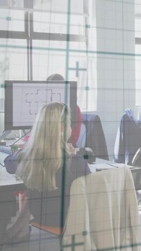 Vertical video: Designer reviewing floor plan on monitor, starting team markup via glass grid