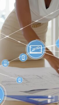Vertical video: Woman smoothing plans and causing blue phone laptop icons connecting across designs