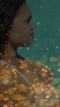 Vertical video: Teen side frame widening showing white strap over teal sea, gold bokeh overlay ads