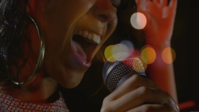 Singer leaning into mic, moving from verse to strong chorus with lights moving for music expression