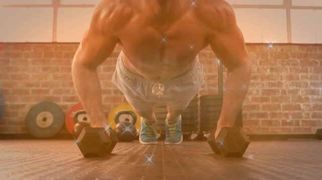 Man bracing on hex dumbbells performing push-ups on gym floor, sparkles showing form for fitness