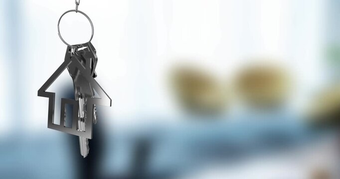 Animation of silver house key fob and key dangling over out of focus interiors with copy space