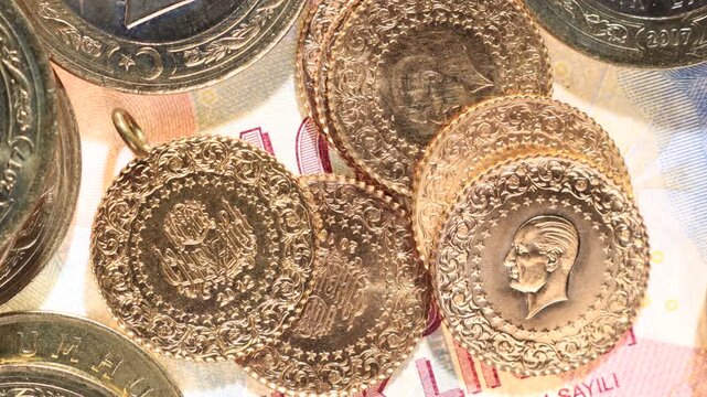 Turkish Republic quarter gold coins showing both obverse and reverse sides with Ataturk portrait on Turkish lira banknote among mixed coins in vertical pan. Close-up
