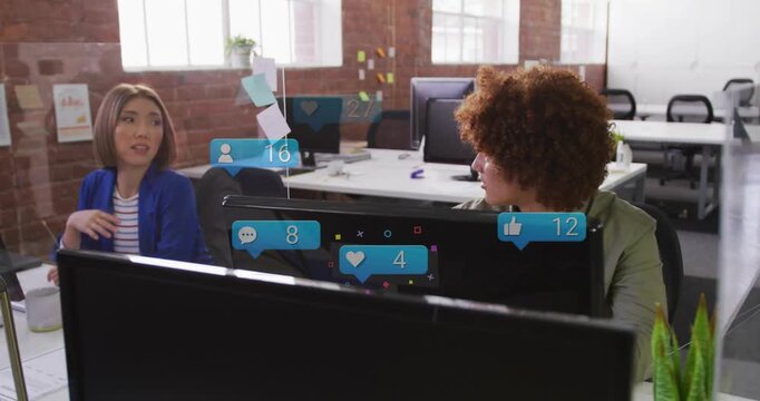Woman gesturing in office toward coworker, starting marketing talk, reaction bubbles rising