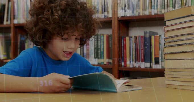 Boy opening blue-covered book at library table, leaning forward and practicing reading skills