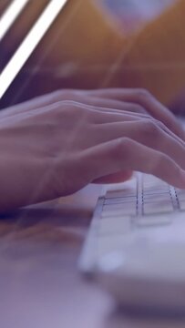 Vertical video: Hand entering and typing on white keys while ghosted charts showing finance months