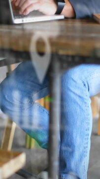 Vertical video: Senior man placing hands on laptop and typing for business, decals overlaying scene