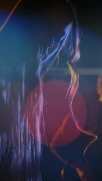 Vertical video: Hand pressing keys, female keyboardist performing live, animated bokeh tracing hair
