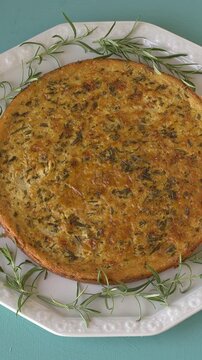 Top view of Italian traditional farinata (chickpea pancake) with rosemary. Table spin. Vertical video.