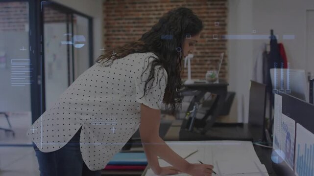 Woman architect placing hands on plans, picking pen, revising plans while HUD guiding edits