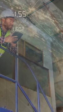 Vertical video: Worker descending blue stair, using tablet, showing AR data for construction checks