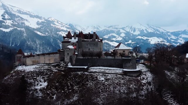 Aerial: close shot of Gruyeres Castle with snow in winter during the day in Canton of Fribourg, Switzerland, orbit drone shot