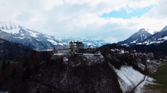 Aerial: Gruyeres Castle with snow in winter during the day in Canton of Fribourg, Switzerland, orbit drone shot