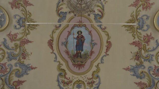 Close up view of religious fresco art and classical patterns on a historic cathedral ceiling.